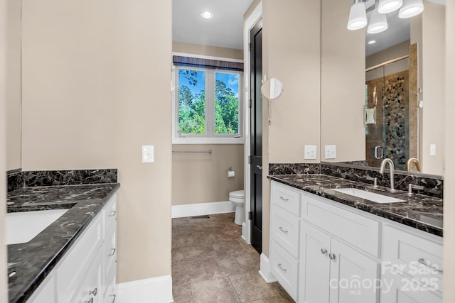 204 Ridge Dr Unit 12 12-1 12-2, Troy, NC 27371 - bathroom featuring baseboards, a stall shower, two vanities, and toilet