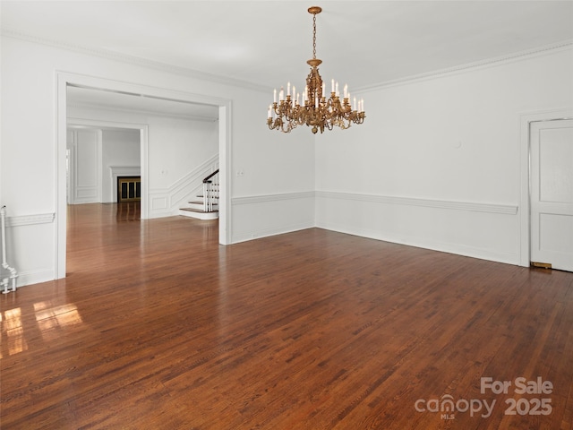 316 Vanderbilt Rd, Asheville, NC 28803 - spare room with stairs, a chandelier, dark wood-style flooring, and crown molding