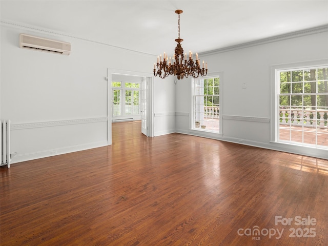 316 Vanderbilt Rd, Asheville, NC 28803 - empty room with a wall mounted air conditioner, a chandelier, wood finished floors, crown molding, and radiator heating unit