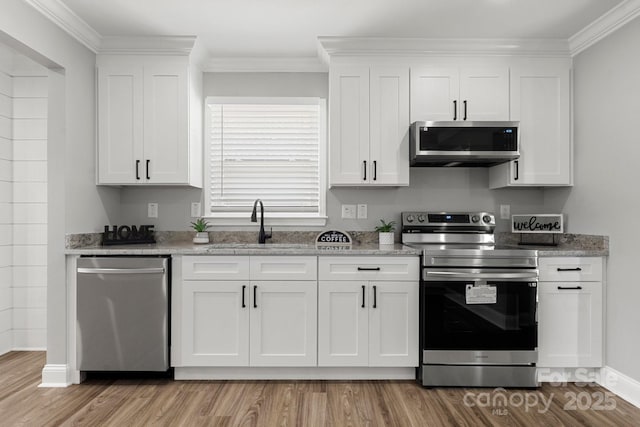 1067 Winchester Dr, Rock Hill, SC 29730 - kitchen featuring stainless steel appliances, a sink, light wood finished floors, white cabinetry, and ornamental molding