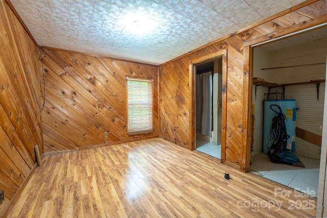 181 Settlers Ln, Waynesville, NC 28785 - spare room featuring light wood-style floors, wood walls, and water heater