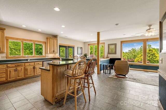 2912 Windswept Ridge Rd, Marshall, NC 28753 - kitchen with a center island, a breakfast bar, recessed lighting, dark stone countertops, and stainless steel dishwasher