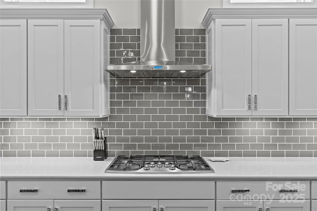 9750 Briarwick Ln, Charlotte, NC 28277 - kitchen featuring wall chimney range hood, stainless steel gas cooktop, light countertops, and tasteful backsplash