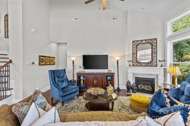 9750 Briarwick Ln, Charlotte, NC 28277 - living room with a towering ceiling, a ceiling fan, a glass covered fireplace, baseboards, and wood finished floors