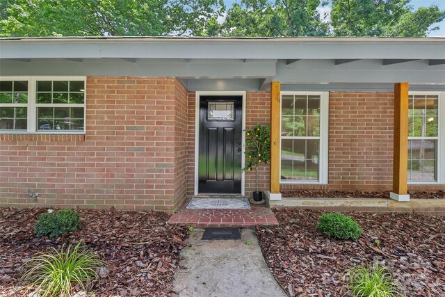 view of exterior entry featuring brick siding