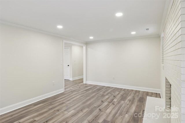 empty room featuring ornamental molding, recessed lighting, baseboards, and wood finished floors