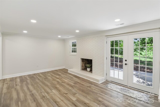 unfurnished living room featuring healthy amount of natural light, wood finished floors, french doors, baseboards, and recessed lighting
