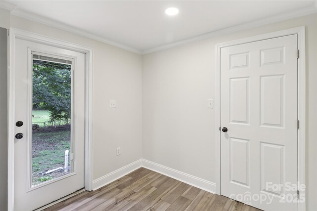 doorway to outside with light wood-type flooring, baseboards, ornamental molding, and recessed lighting