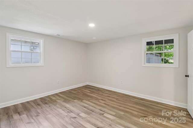 empty room featuring baseboards, wood finished floors, and recessed lighting