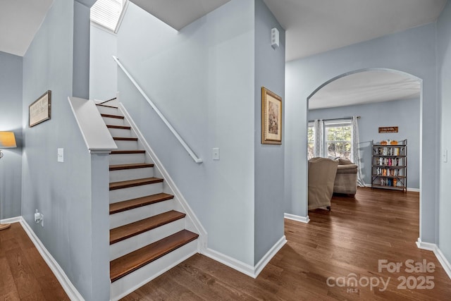 6119 Castlecove Rd, Charlotte, NC 28278 - staircase featuring arched walkways, wood finished floors, and baseboards