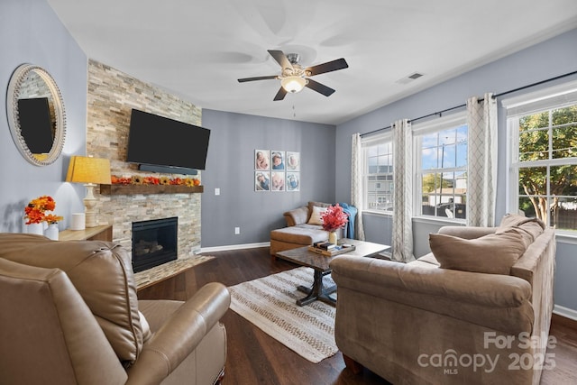 6119 Castlecove Rd, Charlotte, NC 28278 - living area with ceiling fan, dark wood-type flooring, a stone fireplace, and baseboards