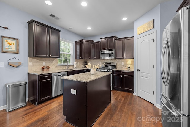 6119 Castlecove Rd, Charlotte, NC 28278 - kitchen with appliances with stainless steel finishes, dark wood finished floors, dark brown cabinetry, backsplash, and recessed lighting