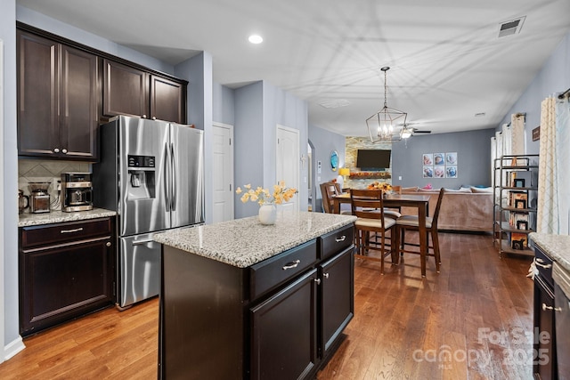 6119 Castlecove Rd, Charlotte, NC 28278 - kitchen featuring stainless steel fridge with ice dispenser, wood finished floors, dark brown cabinetry, decorative backsplash, and recessed lighting