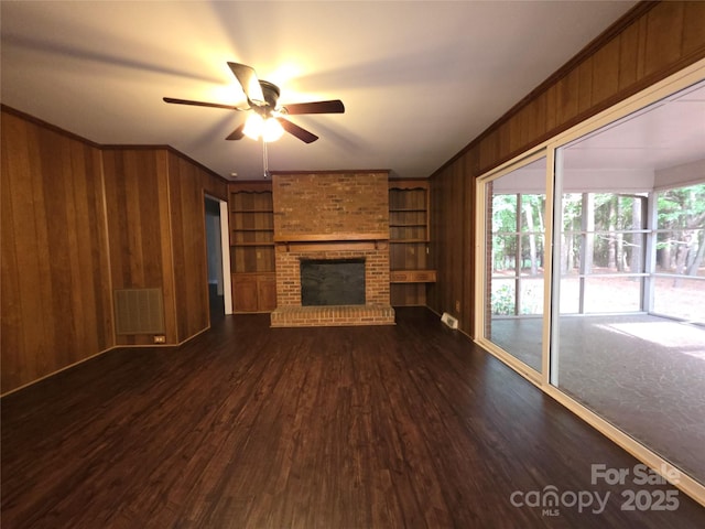 3316 Mckee Rd, Charlotte, NC 28270 - unfurnished living room featuring wooden walls, dark wood-style flooring, a ceiling fan, built in features, and a fireplace