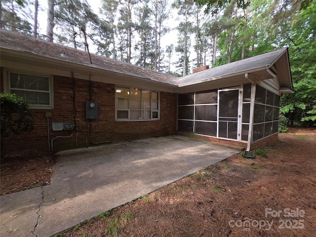 3316 Mckee Rd, Charlotte, NC 28270 - back of property with a sunroom, brick siding, a patio, and a chimney