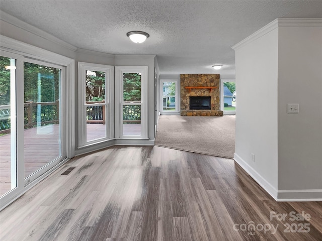 2532 Steeplechase Rd, Gastonia, NC 28056 - unfurnished living room with baseboards, a textured ceiling, a fireplace, wood finished floors, and crown molding