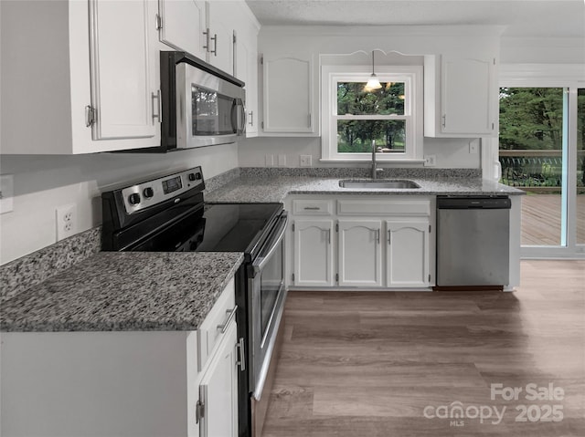 2532 Steeplechase Rd, Gastonia, NC 28056 - kitchen with stainless steel appliances, a sink, wood finished floors, and white cabinets