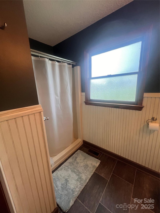 1351 Hardin Rd, Dallas, NC 28034 - full bath with wainscoting, a shower with curtain, a textured ceiling, and tile patterned floors