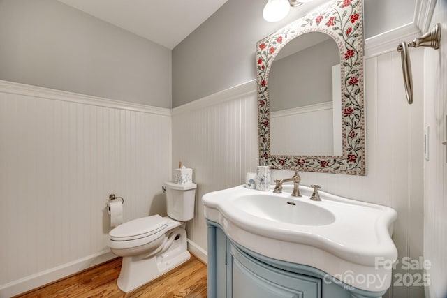 2702 Oxborough Dr, Matthews, NC 28105 - half bath with wood finished floors, toilet, vanity, a wainscoted wall, and baseboards