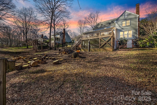 2702 Oxborough Dr, Matthews, NC 28105 - back of house at dusk featuring stairway, a chimney, and a wooden deck