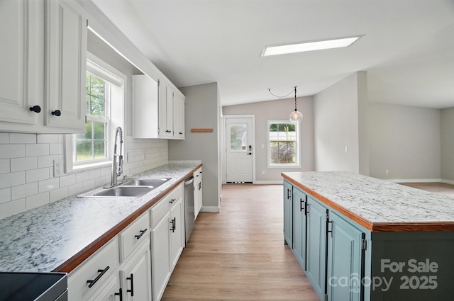 12382 Ritchie Rd, Midland, NC 28107 - kitchen with a sink, white cabinets, backsplash, light wood-style flooring, and vaulted ceiling