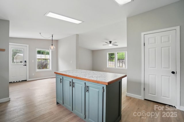 12382 Ritchie Rd, Midland, NC 28107 - kitchen featuring light wood-style flooring, baseboards, blue cabinetry, and light countertops