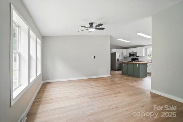 12382 Ritchie Rd, Midland, NC 28107 - unfurnished living room featuring light wood finished floors, a ceiling fan, and baseboards