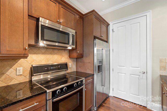 5425 Closeburn Rd Unit 208, Charlotte, NC 28210 - kitchen with stainless steel appliances, ornamental molding, dark wood-type flooring, brown cabinets, and backsplash