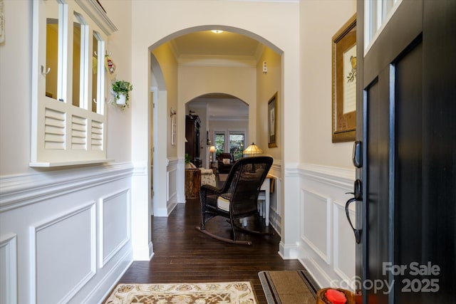 8818 Artesa Mill Ln, Charlotte, NC 28214 - foyer featuring ornamental molding, dark wood-style flooring, a wainscoted wall, a decorative wall, and arched walkways