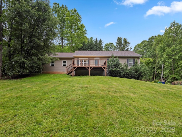 back of property with a deck, a lawn, and stairs