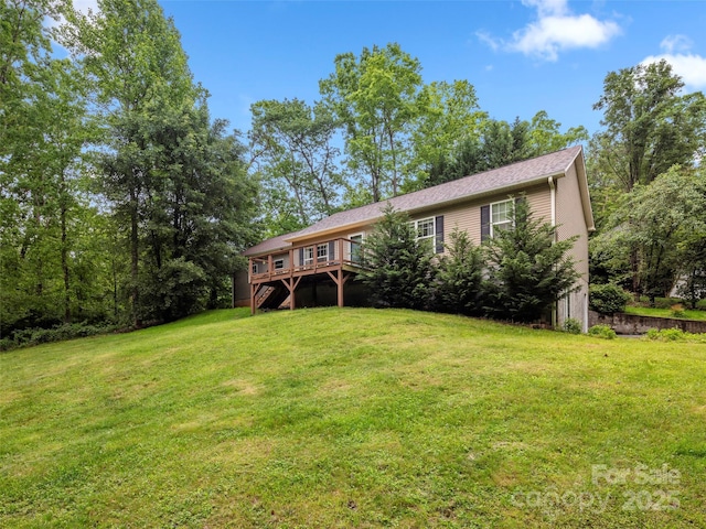 view of green lawn featuring stairs and a deck
