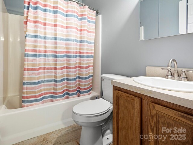 bathroom with shower / bathtub combination with curtain, toilet, vanity, and wood finished floors