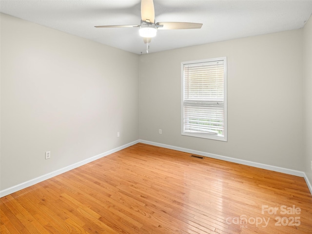 empty room with a ceiling fan, baseboards, and light wood-style flooring