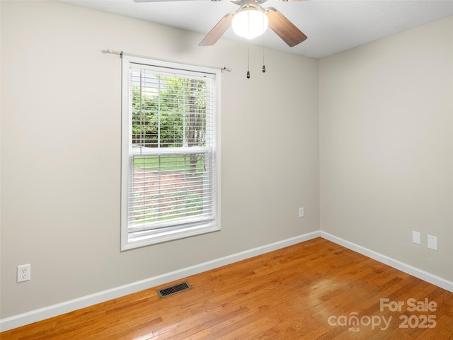 spare room with wood finished floors, baseboards, and ceiling fan