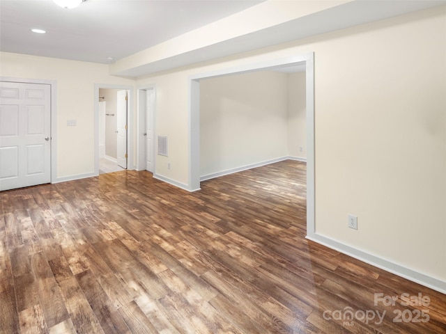 unfurnished room featuring wood finished floors, baseboards, and recessed lighting