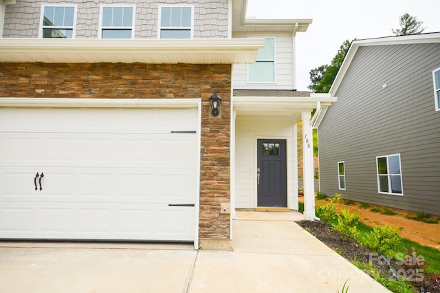 106 Sugg Trl, Weaverville, NC 28787 - property entrance featuring stone siding, an attached garage, and concrete driveway