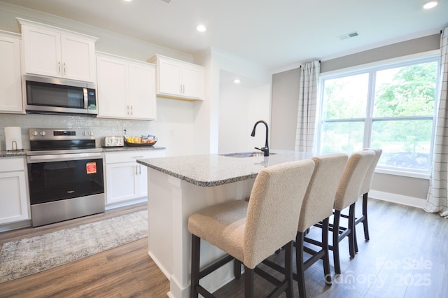 106 Sugg Trl, Weaverville, NC 28787 - kitchen featuring appliances with stainless steel finishes, wood finished floors, decorative backsplash, light stone counters, and recessed lighting