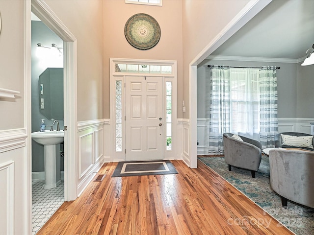 3409 Valdosta Ct, Monroe, NC 28110 - foyer with a decorative wall, plenty of natural light, wood finished floors, a wainscoted wall, and ornamental molding