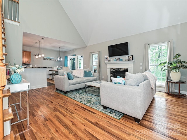 3409 Valdosta Ct, Monroe, NC 28110 - living area with wood finished floors, plenty of natural light, a fireplace, high vaulted ceiling, and a chandelier