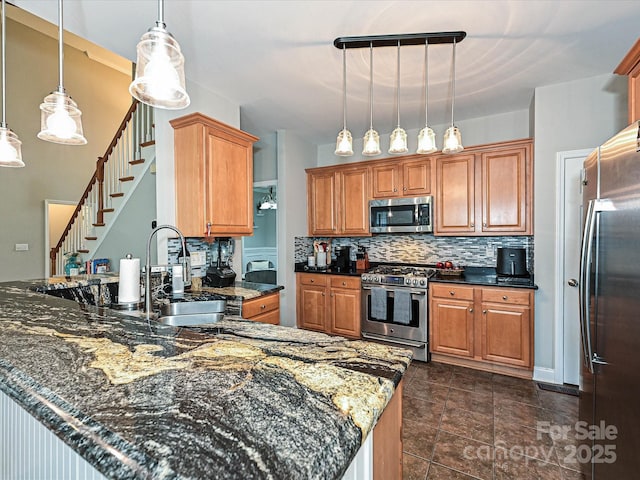 3409 Valdosta Ct, Monroe, NC 28110 - kitchen featuring stainless steel appliances, a sink, tasteful backsplash, dark stone counters, and brown cabinetry