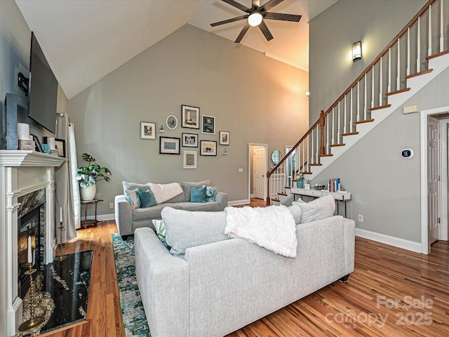 3409 Valdosta Ct, Monroe, NC 28110 - living room with a ceiling fan, high vaulted ceiling, stairs, wood finished floors, and a high end fireplace