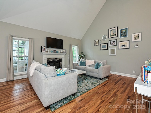 3409 Valdosta Ct, Monroe, NC 28110 - living area featuring healthy amount of natural light, wood finished floors, high vaulted ceiling, and baseboards