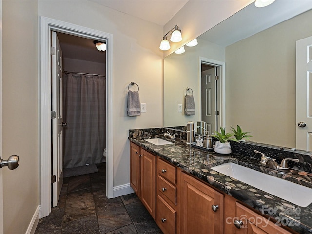 3409 Valdosta Ct, Monroe, NC 28110 - full bathroom featuring baseboards, stone tile flooring, double vanity, and toilet