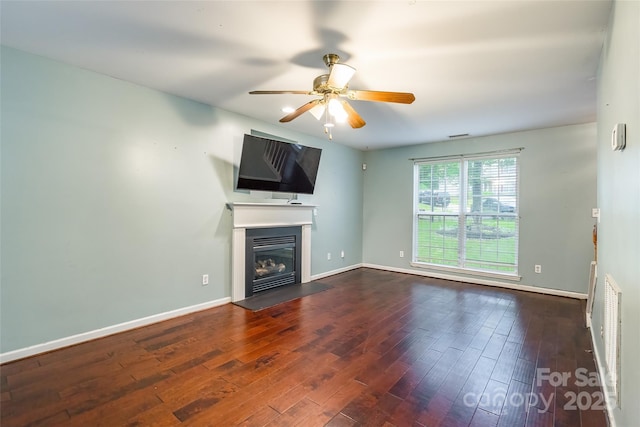 7206 Stoney Place Ct, Charlotte, NC 28262 - unfurnished living room featuring ceiling fan, a glass covered fireplace, dark wood-type flooring, and baseboards