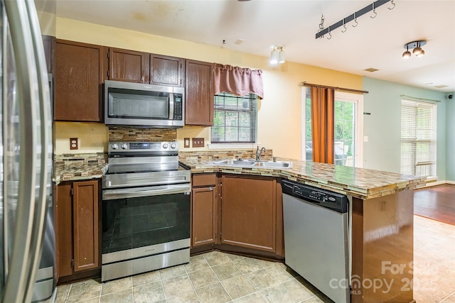 7206 Stoney Place Ct, Charlotte, NC 28262 - kitchen with stainless steel appliances, a sink, a peninsula, decorative backsplash, and light tile patterned floors