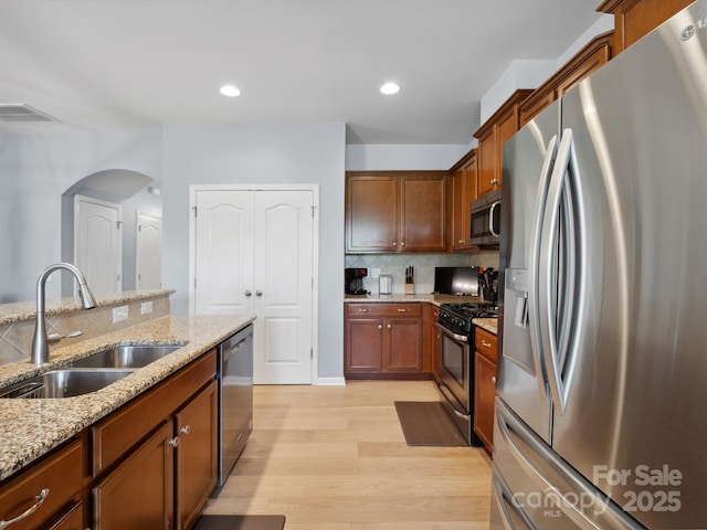 3306 Yarmouth Ln, Gastonia, NC 28056 - kitchen with stainless steel appliances, light wood-type flooring, decorative backsplash, light stone counters, and recessed lighting