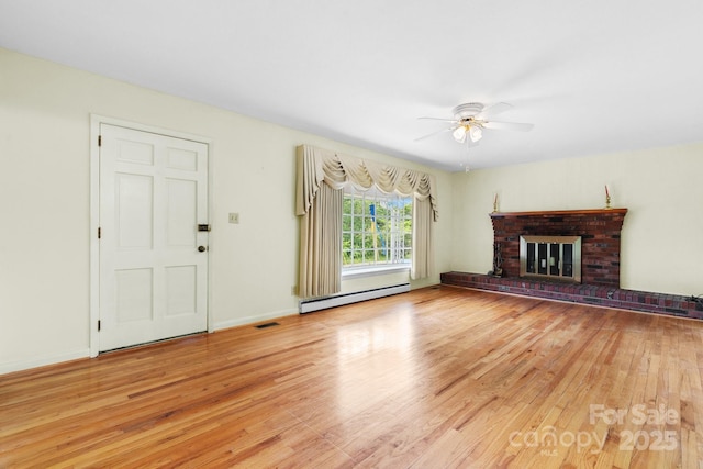 713 Crozet St NW, Valdese, NC 28690 - unfurnished living room featuring a baseboard heating unit, wood finished floors, ceiling fan, and a fireplace