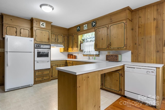 713 Crozet St NW, Valdese, NC 28690 - kitchen featuring white appliances, under cabinet range hood, a peninsula, a warming drawer, and light countertops