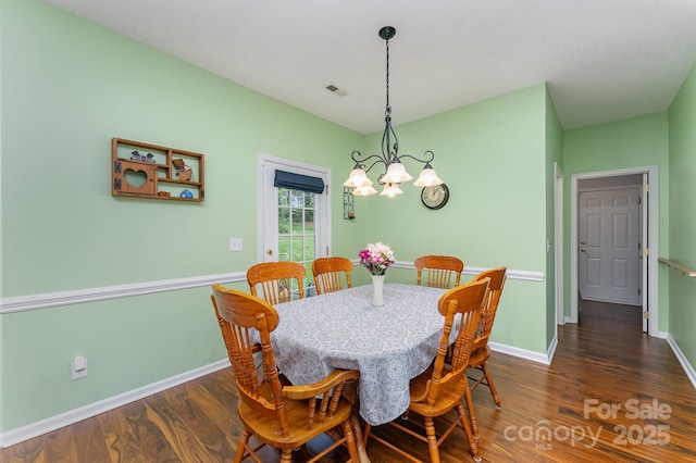 10322 Stoneykirk Ln, Charlotte, NC 28269 - dining area featuring a chandelier, dark wood-style floors, and baseboards