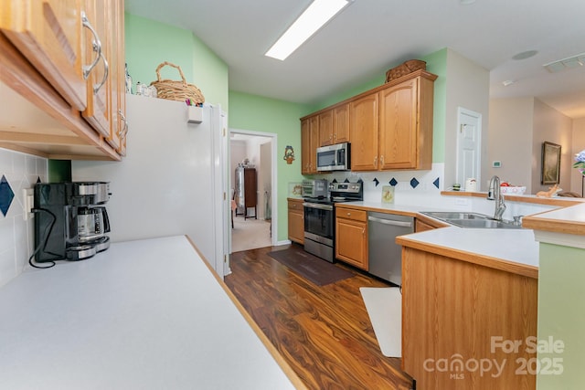 10322 Stoneykirk Ln, Charlotte, NC 28269 - kitchen featuring stainless steel appliances, a sink, dark wood-type flooring, tasteful backsplash, and light countertops